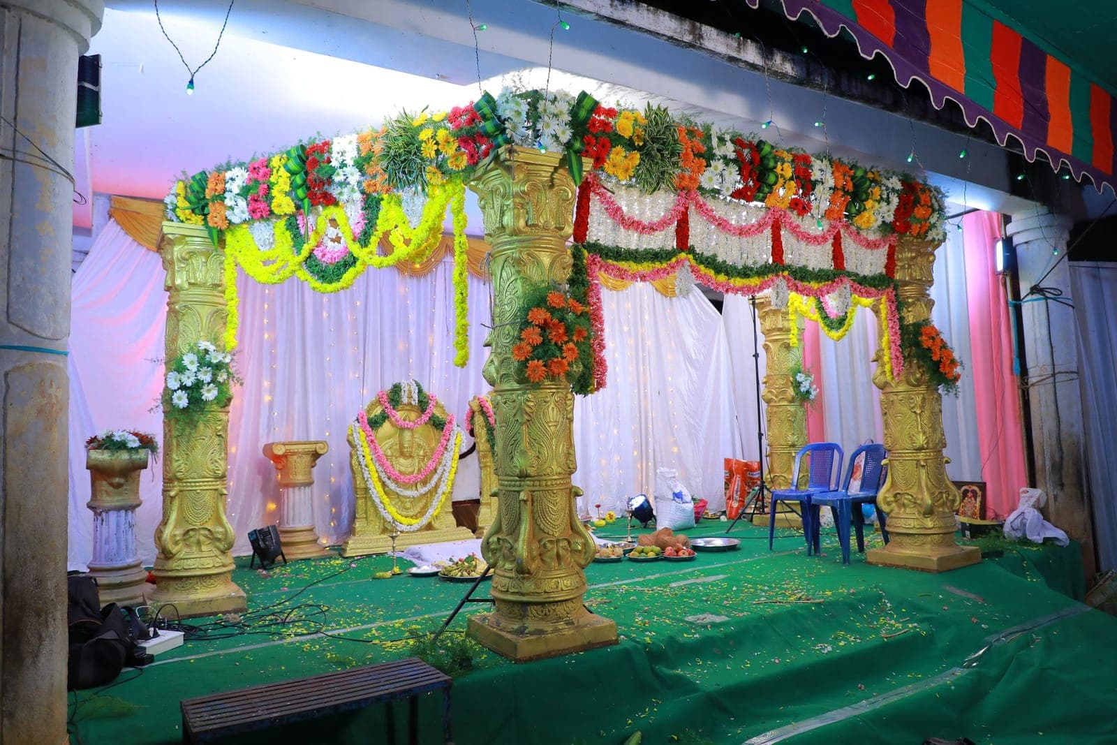 Gold columns and a floral stage set for a Pakistani wedding